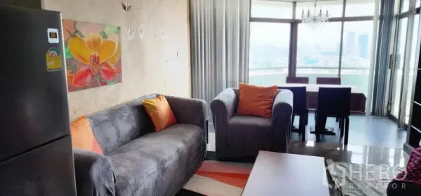 公寓 出售在Watthana, Bangkok - 开放式客餐厅，沙发组连接景观餐区与吊灯。