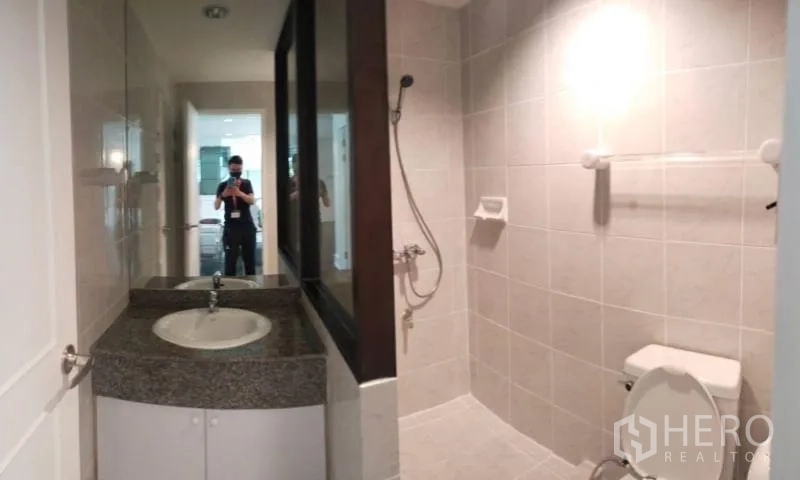 Condominium for rent in Sathon, Bangkok - Second bathroom with walk-in shower, toilet and granite-top vanity.