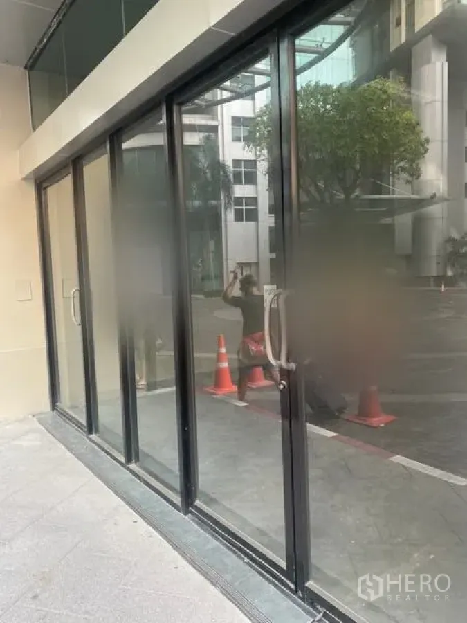 零售空间 出租在Khlong Toei, Bangkok - 临街玻璃店面，黑色铝框与推拉门。