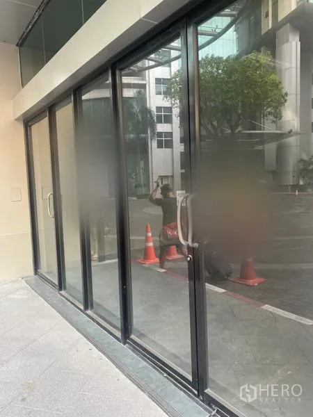 零售空间 出租在Khlong Toei, Bangkok - 临街玻璃店面，黑色铝框与推拉门。