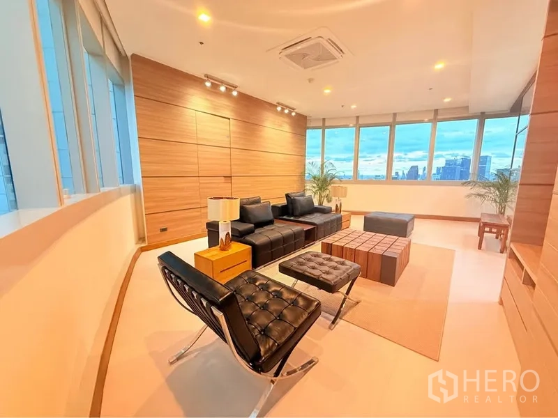 คอนโด ให้เช่าหรือขายในKhlong Toei, Bangkok - พื้นที่นั่งเล่นสมัยใหม่ ผนังไม้ ฝ้าไฟสปอร์ตไลท์ โซฟาหนัง รายล้อมด้วยหน้าต่างโค้งรอบ