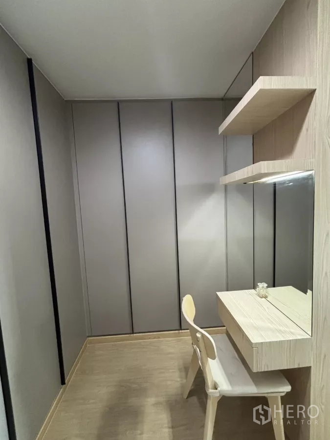 Condominium for rent in Phra Khanong, Bangkok - Compact dressing room with built-in wardrobes and a vanity desk.