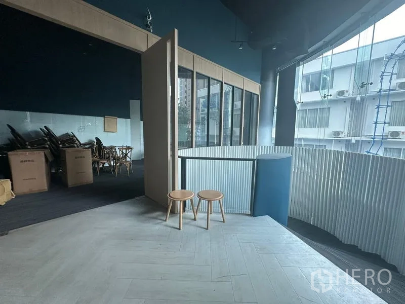 Office Space for rent - Upper level corner with folding partition room, curved balcony edge and city view through glass facade.