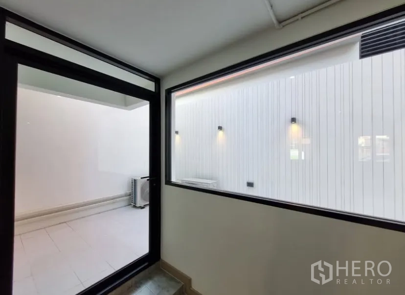 Detached House for rent in Suan Luang, Bangkok - Enclosed lightwell with wall lights viewed through a large window.
