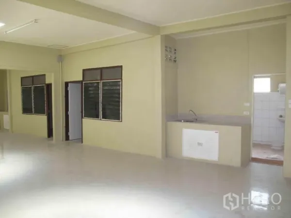 Warehouse for rent in Wang Thonglang, Bangkok - Utility zone with sink and doorway to tiled restroom inside the warehouse.