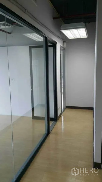 办公空间 出租在Khlong Toei, Bangkok - 走廊配落地玻璃隔断与荧光照明。