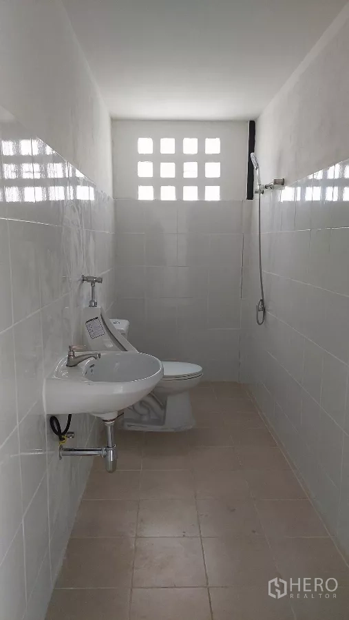 货栈 出租在Khlong Toei, Bangkok - 仓库内干净的瓷砖卫生间，含坐便器、洗手盆和淋浴。