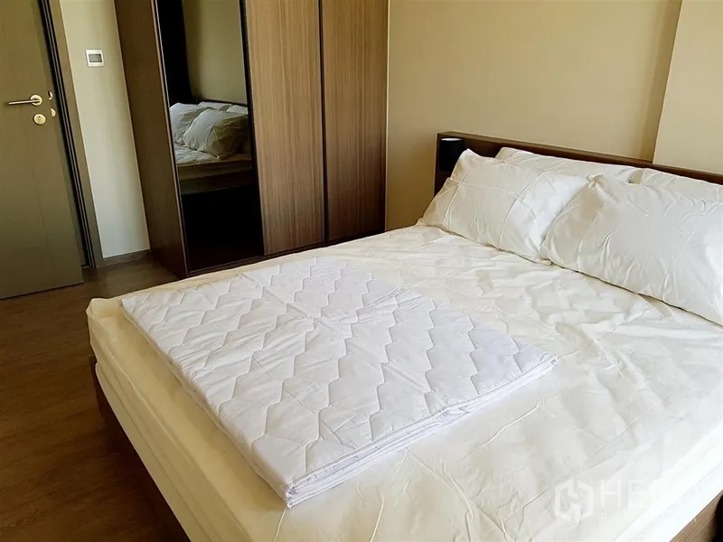 Condominium for rent in Watthana, Bangkok - Guest bedroom with double bed and sliding wardrobe doors.