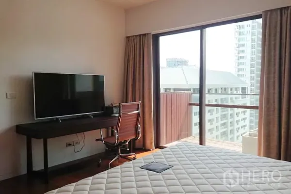 คอนโด ขายในPathum Wan, Bangkok - ห้องนอนมีโต๊ะทำงานและทีวี ติดประตูกระจกบานเลื่อนออกระเบียงชมวิวเมือง