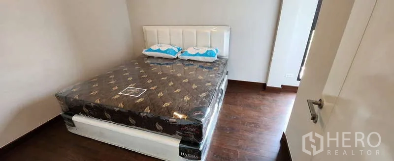 Detached House for rent in Wang Thonglang, Bangkok - Cozy bedroom with wood flooring and queen bed, naturally lit by a side window.