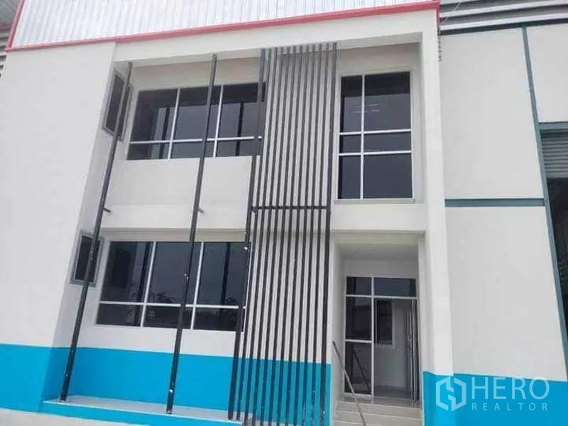 Warehouse for rent in Bang Phli, Samut Prakan - Modern two-storey warehouse facade with large windows and vertical metal fins.