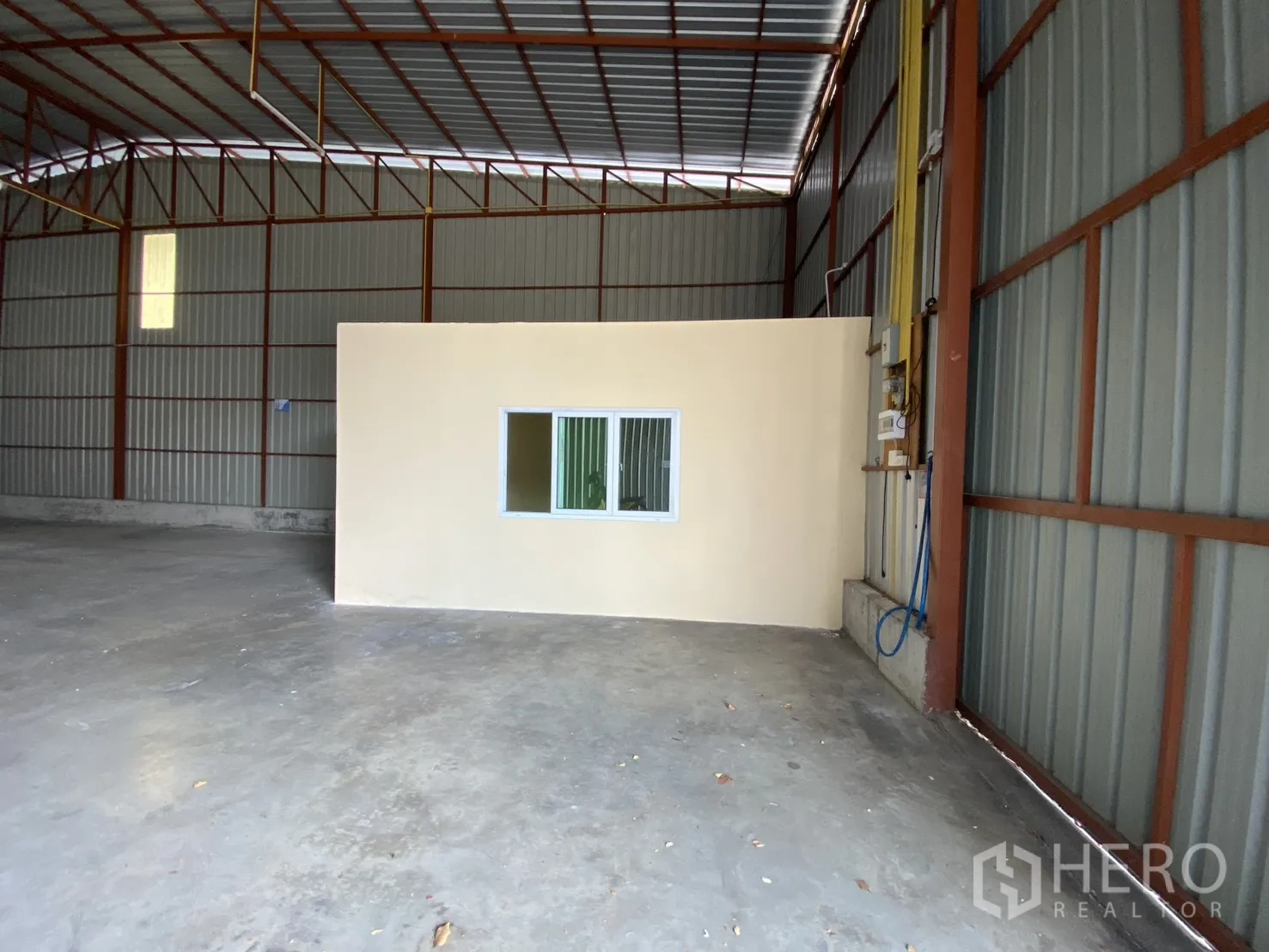 Warehouse for rent in Bueng Kum, Bangkok - Office cabin by the entrance with visible electrical panel and utility lines.