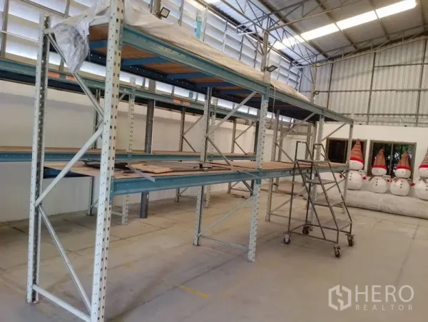 Warehouse for rent in Huai Khwang, Bangkok - Industrial shelving rows with rolling ladder in a bright, ventilated warehouse space.