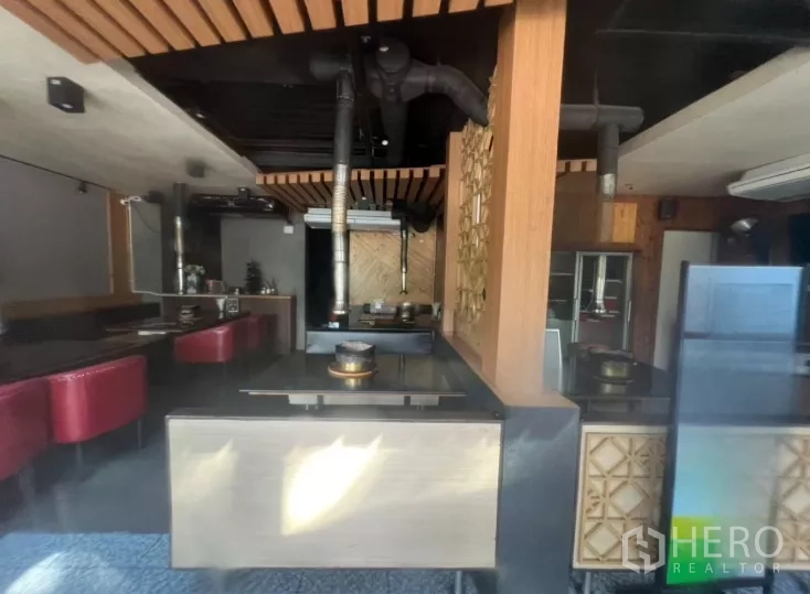 零售空间 出租在Watthana, Bangkok - 餐饮式布局，内置餐桌、红色卡座和天花排烟管，适合餐馆使用。