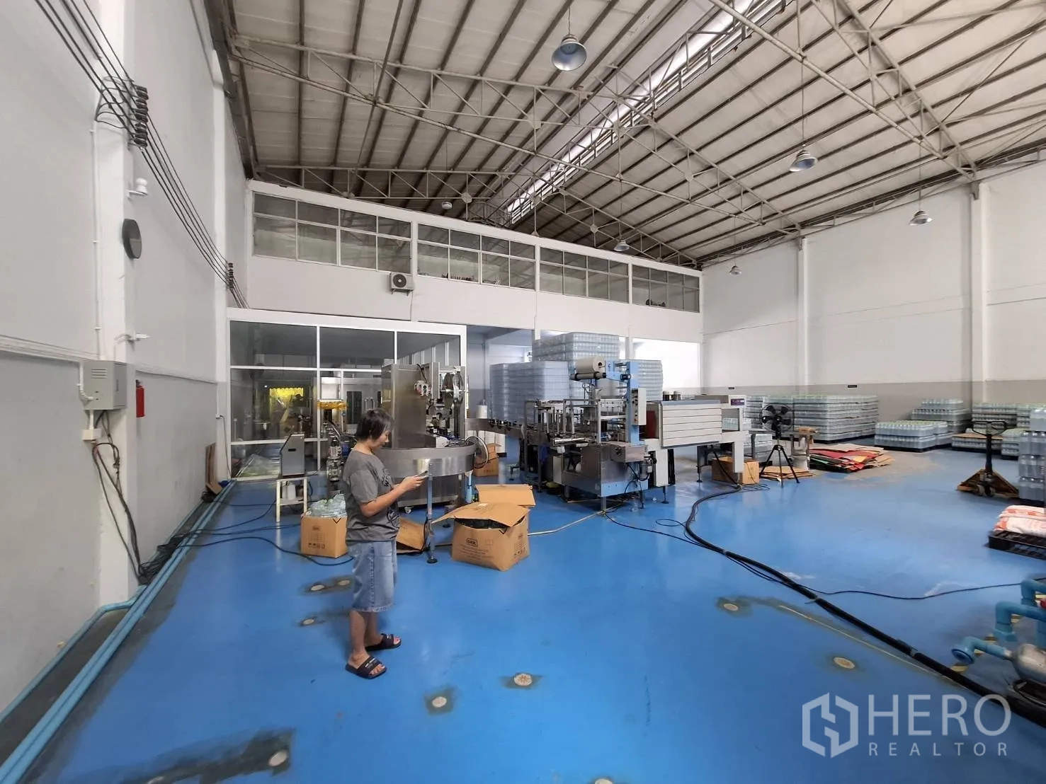 Factory for rent in Bang Phli, Samut Prakan - Production area with blue epoxy floor, industrial machines and a glass-partitioned office.