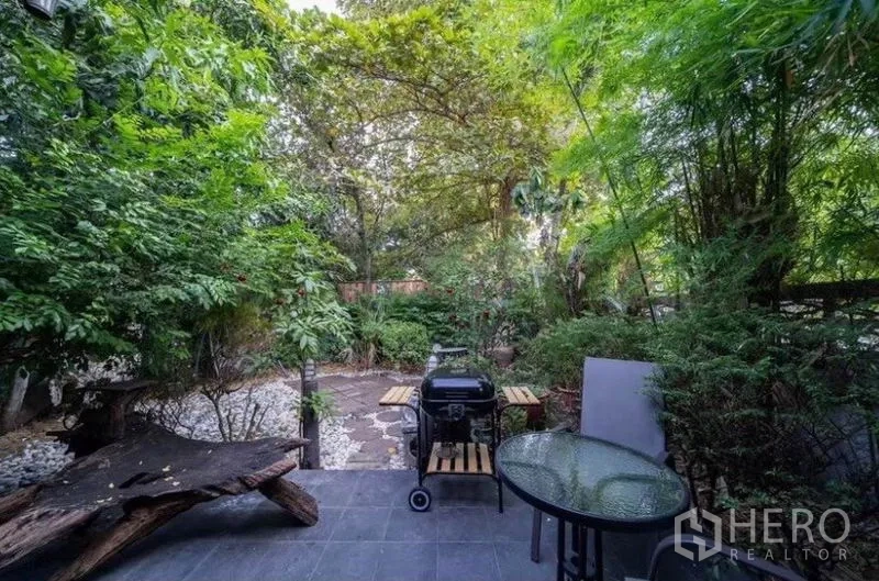 Detached House for rent in Ratchathewi, Bangkok - Leafy backyard patio featuring a BBQ grill and round glass table.
