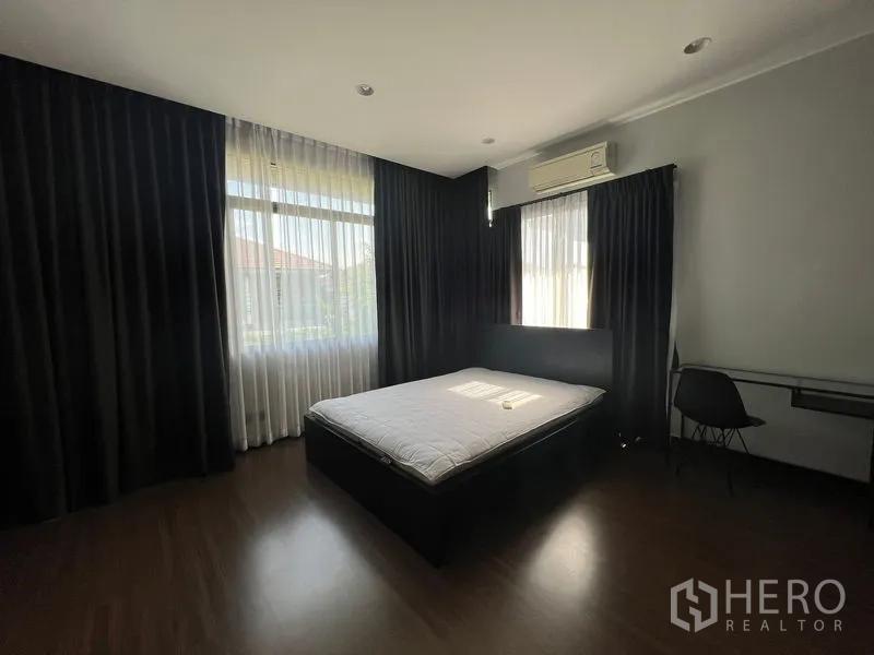 บ้าน ให้เช่าหรือขายในBang Kapi, Bangkok - ห้องนอนสว่างพร้อมเตียง ผ้าม่านยาวเต็มผนัง และแอร์แบบแยกส่วน