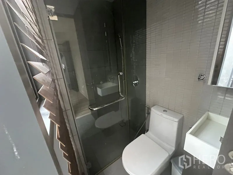 สำนักงาน ให้เช่า - ห้องน้ำสไตล์โมเดิร์นพร้อมตู้กระจกอาบน้ำ โถสุขภัณฑ์ และผนังกรุไทล์