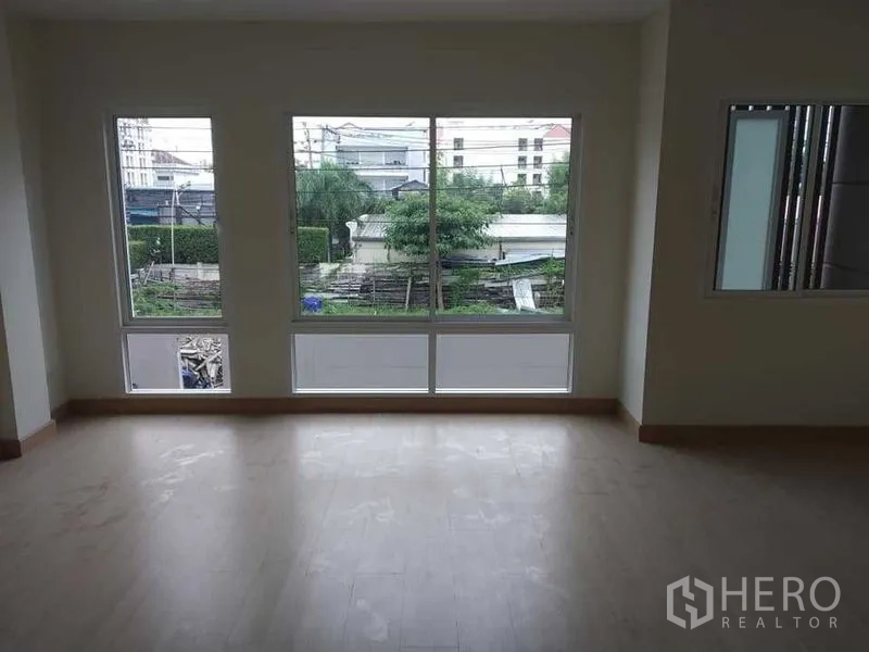 带办公室的家 出租在Prawet, Bangkok - 宽敞室内，三扇大窗与浅色木地板。