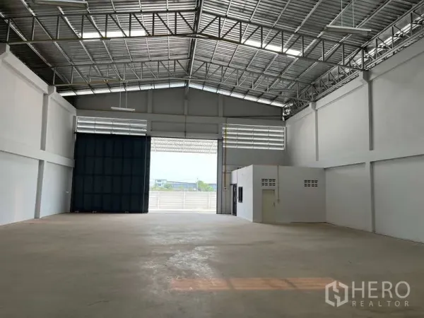 คลังสินค้า ให้เช่าในSam Phran, Nakhon Pathom - ภายในโกดังโล่งโปร่ง หลังคาเหล็กสูงมีช่องแสง พื้นคอนกรีต และประตูม้วนขนาดกว้าง