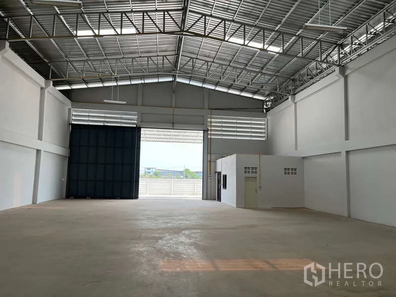 คลังสินค้า ให้เช่าในSam Phran, Nakhon Pathom - ภายในโกดังโล่งโปร่ง หลังคาเหล็กสูงมีช่องแสง พื้นคอนกรีต และประตูม้วนขนาดกว้าง