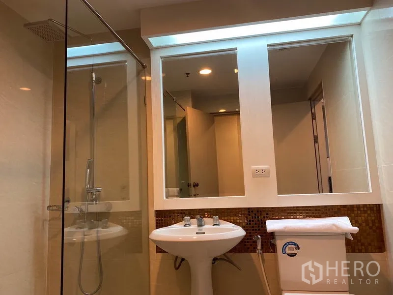 公寓 出租在Watthana, Bangkok - 玻璃淋浴间、立柱式洗手盆、坐便器与双面镜。