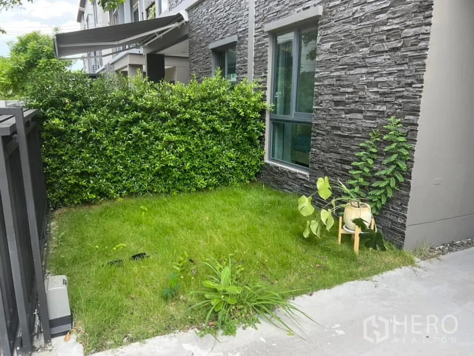 Semi-detached House for rent in Saphan Sung, Bangkok - Modern semi-detached house exterior with stone accents, covered carport, and small lawn.