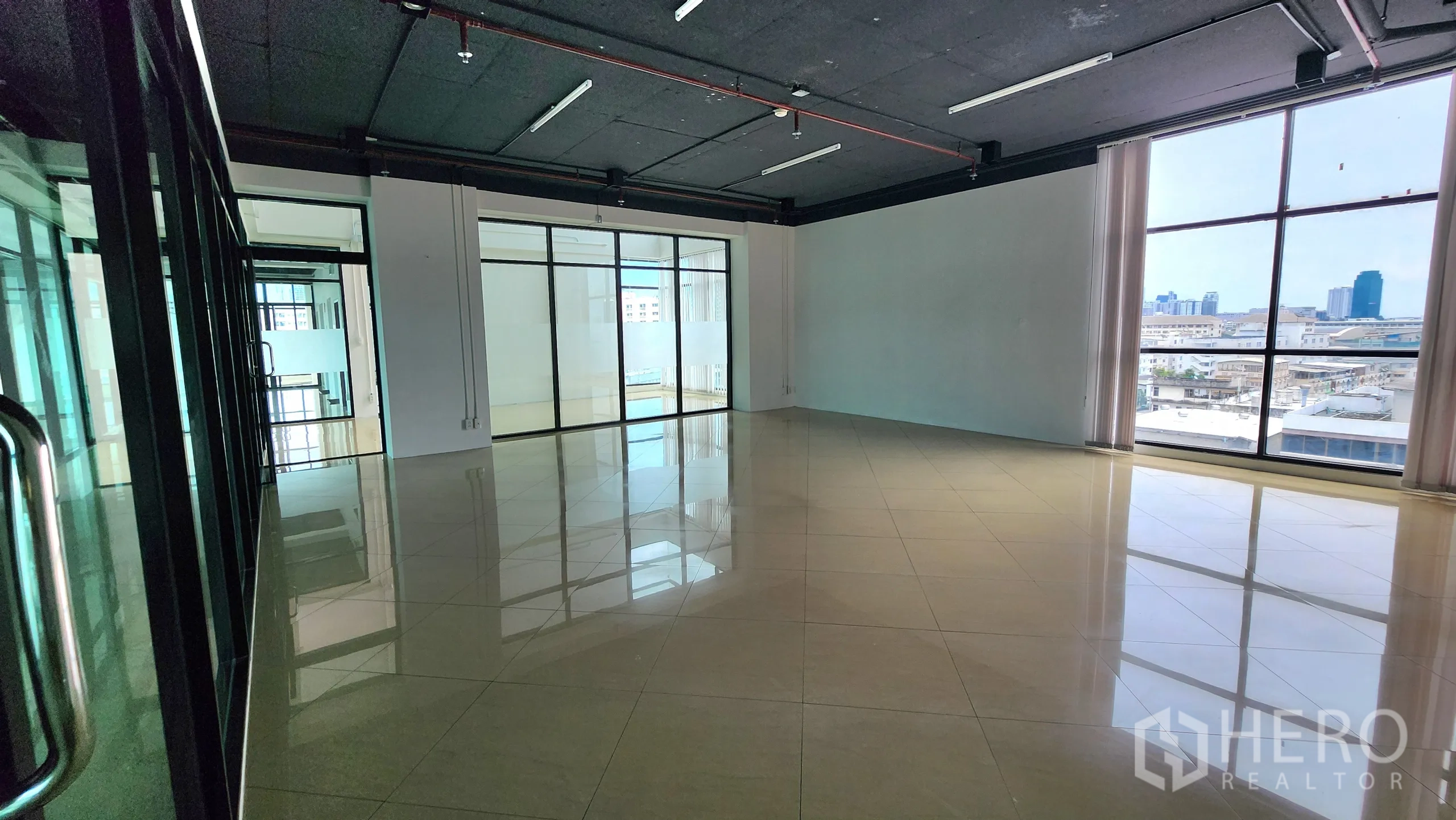 Office Space for rent in Yan Nawa, Bangkok - Large open plan room with single window and black acoustic ceiling.