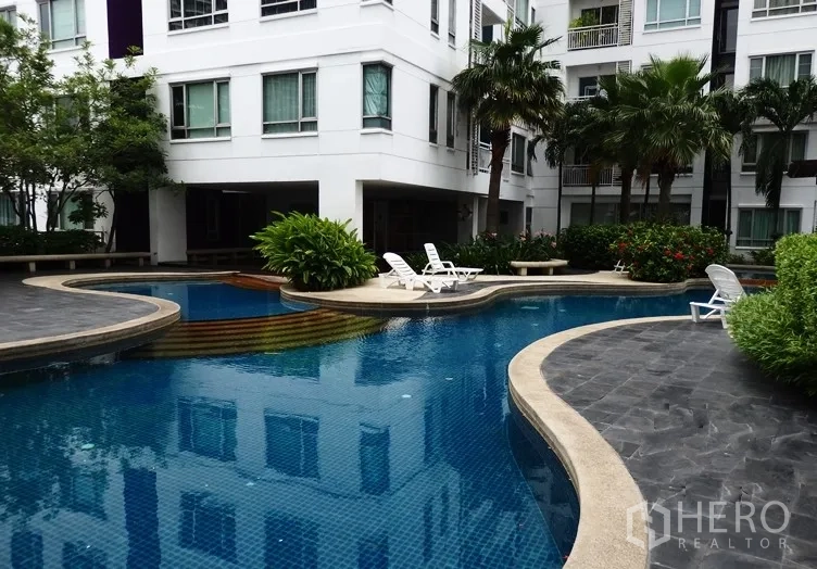 คอนโด ให้เช่าหรือขายในKhlong Toei, Bangkok - ส่วนกลางคอนโดมีสระว่ายน้ำทรงฟรีฟอร์ม เก้าอี้อาบแดด และต้นปาล์ม