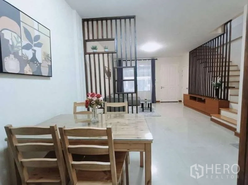 联排别墅 出租在Bang Kapi, Bangkok - 餐区配木质餐桌椅，临装饰木栅隔断。