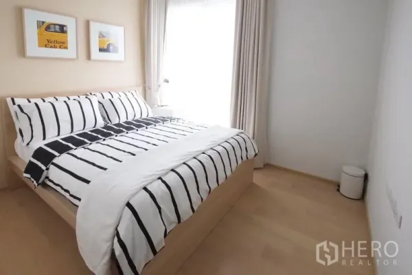 公寓 出租在Watthana, Bangkok - 次卧配条纹床品与浅色木地板，自然光充沛