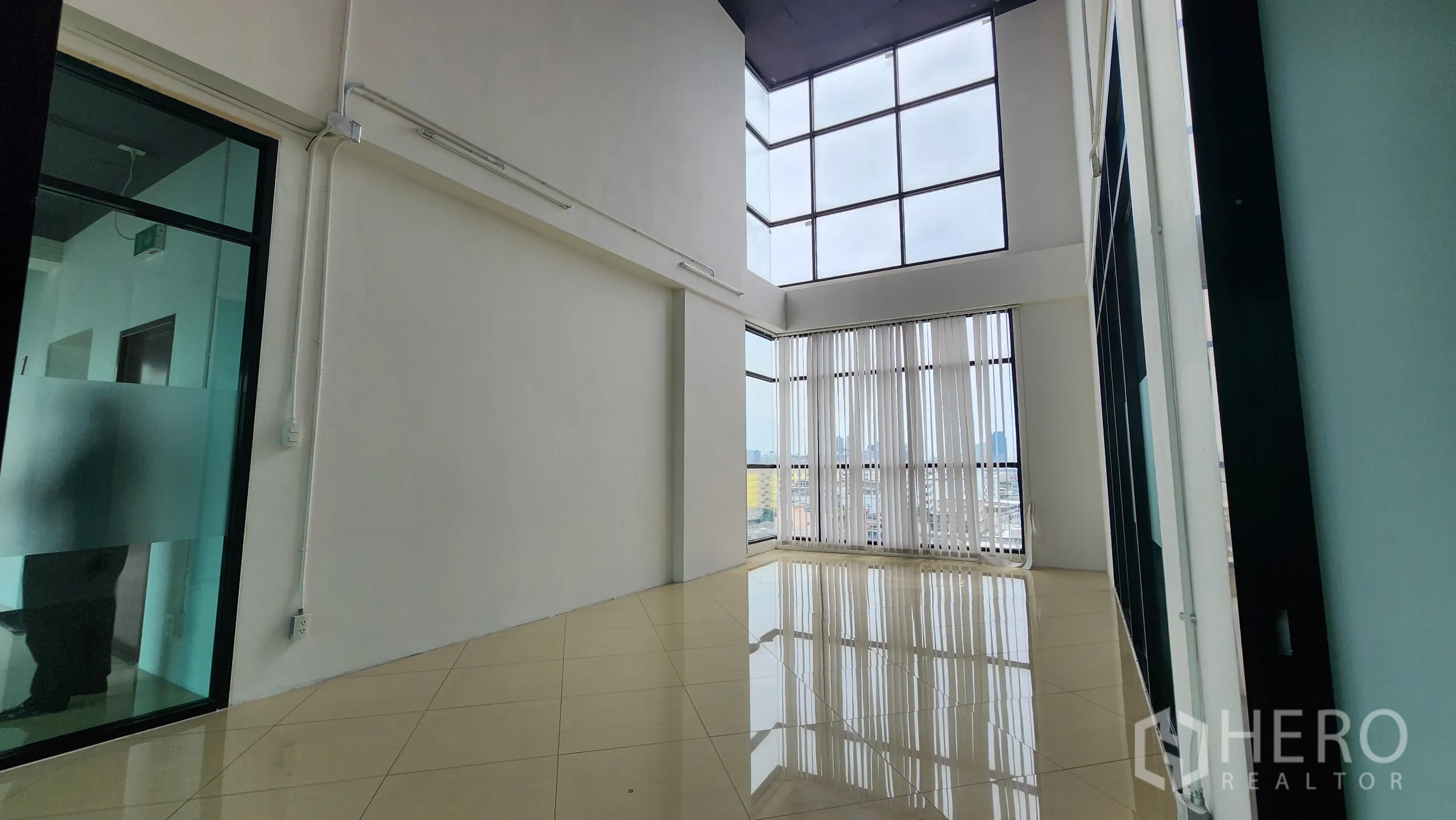 Office Space for rent in Yan Nawa, Bangkok - High-ceiling workspace with vertical blinds and frosted glass partition.