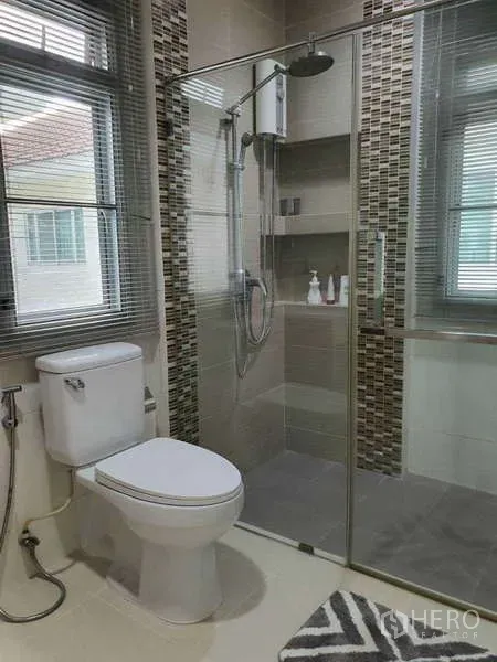 Detached House for rent in Saphan Sung, Bangkok - Contemporary bathroom with glass‑enclosed shower, toilet and window blinds.