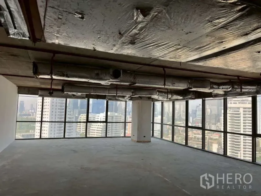 Office Space for rent - High-floor corner bare-shell office with floor-to-ceiling windows and Bangkok skyline views.