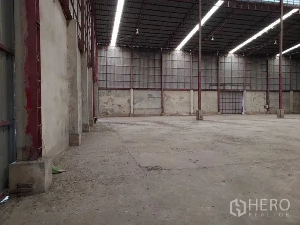 Warehouse for rent in Lat Lum Kaeo, Pathum Thani - Spacious warehouse interior with high steel-truss roof and long skylight strips.