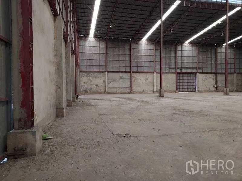 Warehouse for rent in Lat Lum Kaeo, Pathum Thani - Spacious warehouse interior with high steel-truss roof and long skylight strips.