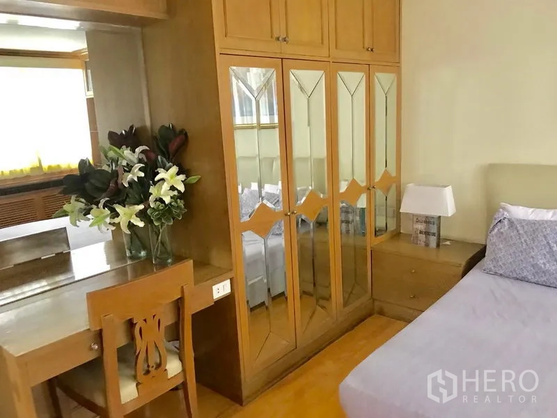 คอนโด ให้เช่าในWatthana, Bangkok - มุมห้องนอนพร้อมตู้เสื้อผ้าบานกระจก โต๊ะเครื่องแป้ง และโคมไฟข้างเตียง