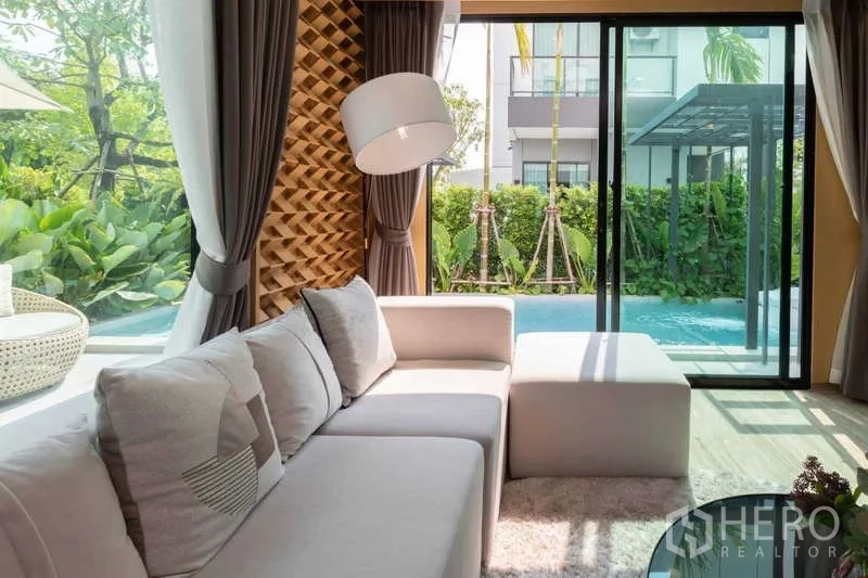 บ้าน ให้เช่าหรือขายในLat Krabang, Bangkok - ห้องนั่งเล่นโซฟา L มองเห็นสระว่ายน้ำส่วนตัวและสวนผ่านประตูกระจกบานเลื่อน