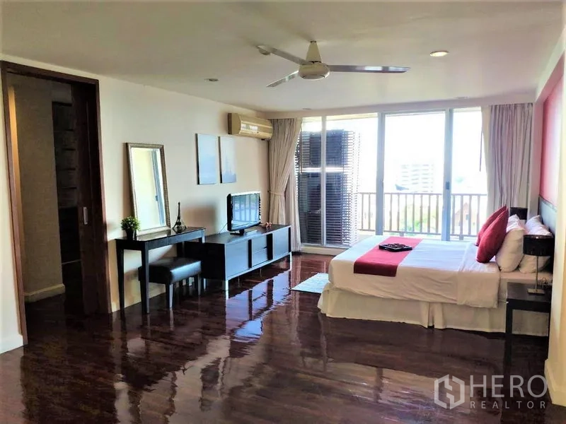 公寓 出租在Bang Rak, Bangkok - 主卧宽敞，带吊扇、阳台及城市景观，并设电视柜。