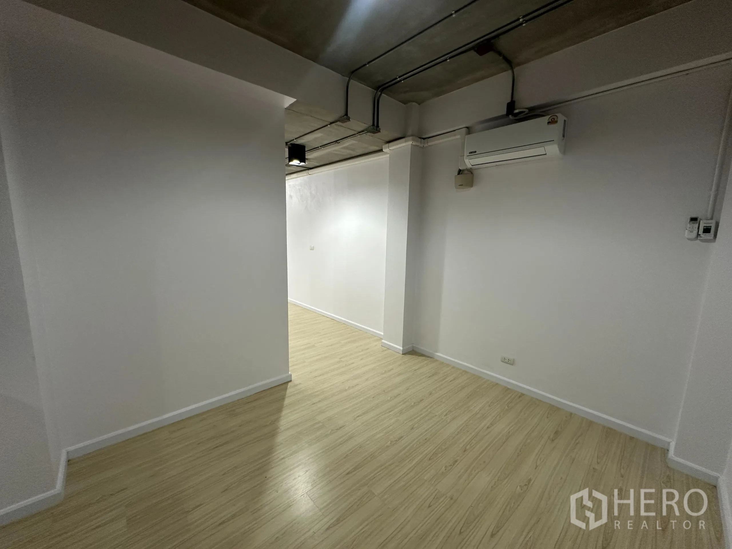 Office Space for rent in Watthana, Bangkok - Small corridor and nook with light wood floors and a wall-mounted split air conditioner.