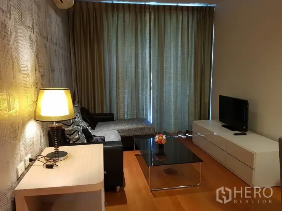 คอนโด ให้เช่าในRatchathewi, Bangkok - พื้นที่นั่งเล่นอบอุ่น ตู้วางทีวี โซฟาเข้ามุม โต๊ะกลางกระจก และผ้าม่านทึบ