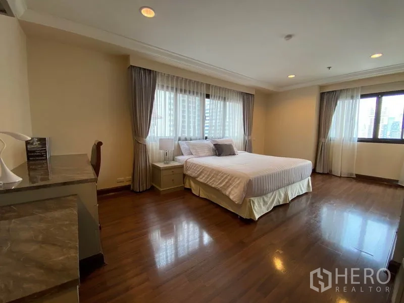 Condominium for rent in Watthana, Bangkok - Third bedroom with double bed, corner windows, desk and city outlook.