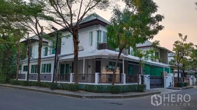 Detached House for rent in Bang Phli, Samut Prakan - Corner view of a modern two-storey detached house on a tree-lined street.