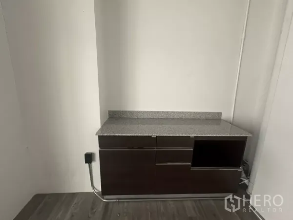 零售空间 出租 - 店内配有内置茶水柜，花岗岩台面，背景为白色墙面。