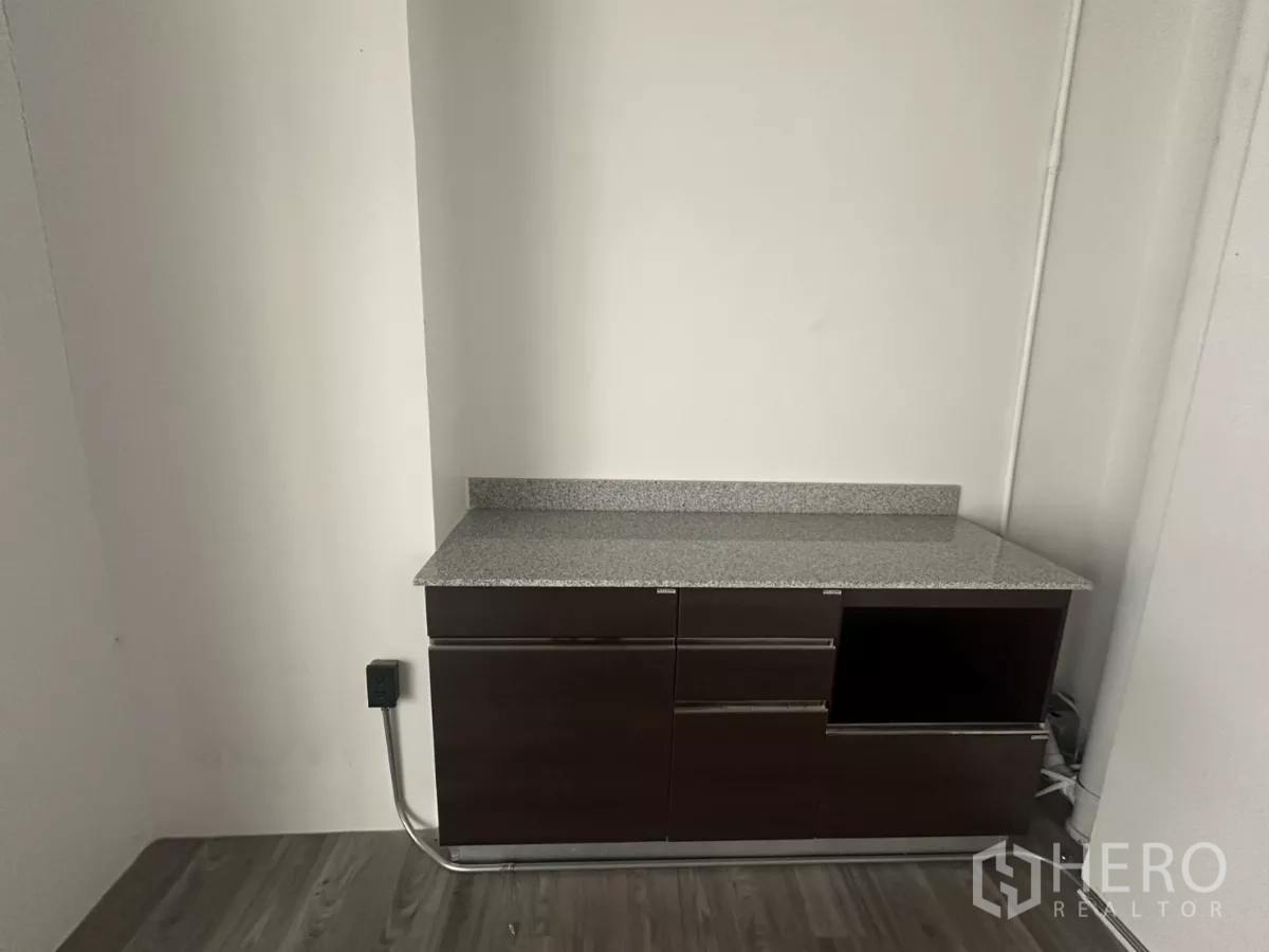 零售空间 出租 - 店内配有内置茶水柜，花岗岩台面，背景为白色墙面。