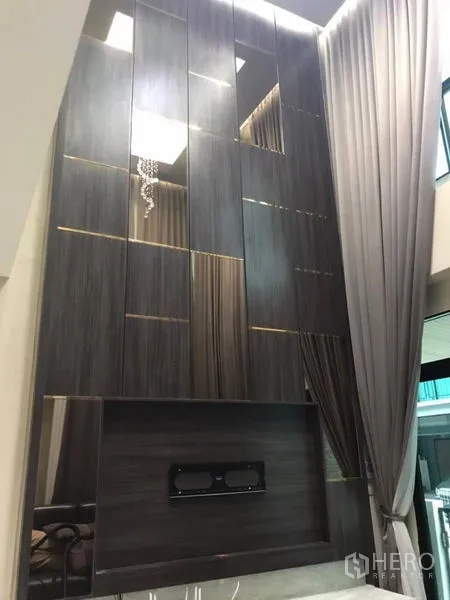 Detached House for rent in Thanyaburi, Pathum Thani - Dramatic double-height feature wall with wood panels and display niches.