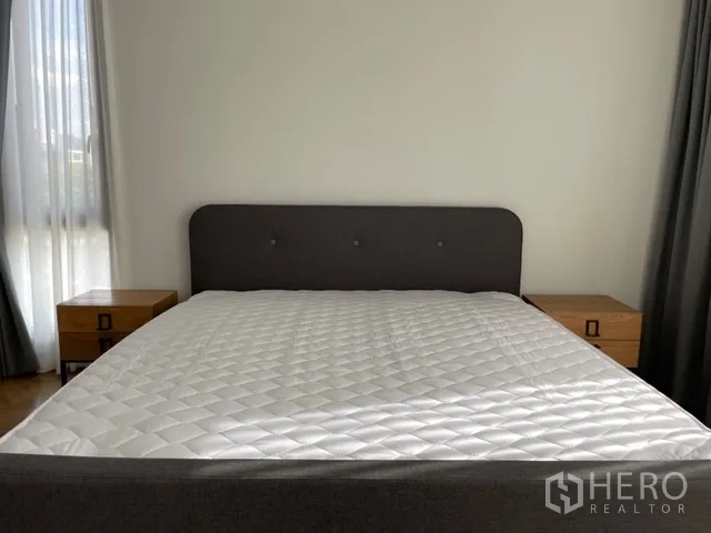 Detached House for rent in Watthana, Bangkok - Front view of bedroom with double bed and matching wooden nightstands.