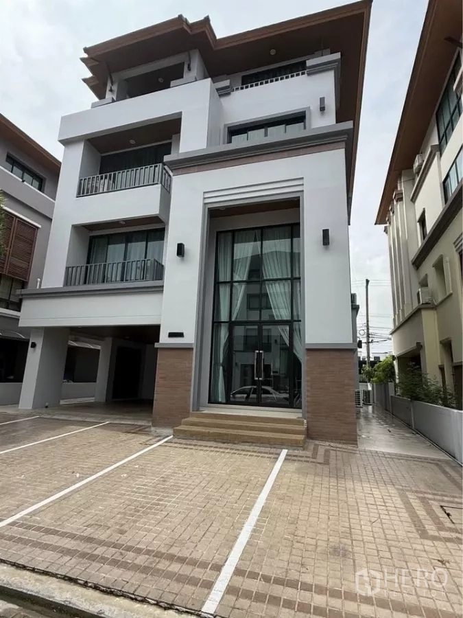 Home Office for rent in Wang Thonglang, Bangkok - Modern four-storey home office exterior with tall glass entrance and marked parking bays.