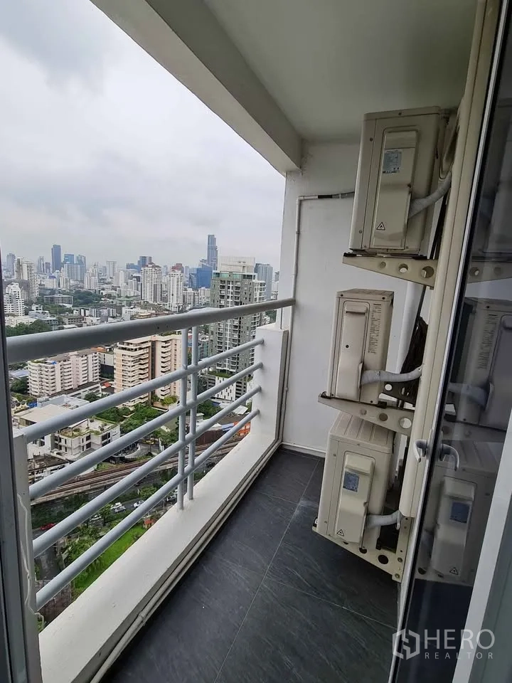 Condominium for rent in Khlong Toei, Bangkok - Balcony corner with railings and air-conditioning compressors, city view.
