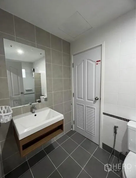 独立式住宅 出租在Suan Luang, Bangkok - 卫生间盥洗台，大镜子与灰色地砖